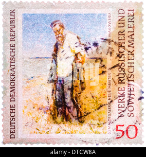 Gedruckt in Deutschland (DDR) Stempel zeigt Bild von Vladimir Makovsky "Mann am Fluss" Stockfoto