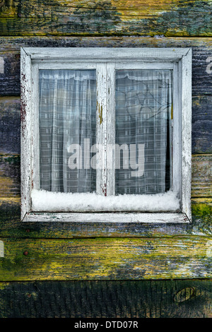 Schäbigen Fenster auf einem hölzernen Hintergrund im winter Stockfoto