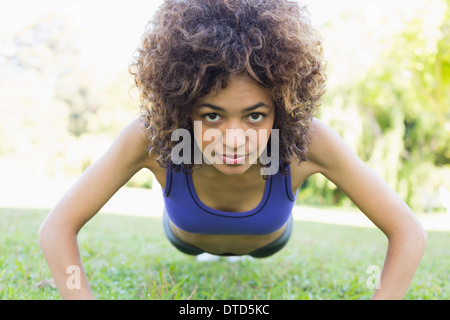 Sportliche Frau doing Push-ups im Park Stockfoto