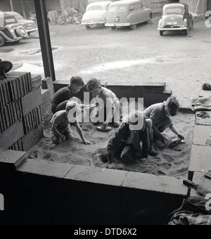 1950er und eine historische Bild zeigt eine Gruppe von kleinen Jungs, die spielen in einer Sandgrube an eine Ziegelei, England Stockfoto