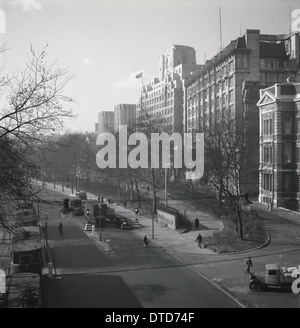 1940er Jahre, zeigt historische, äußere Ansicht und Straßenszenen Umgebung von Victoria Embankment von der Rückseite des Savoy Hotels, London, die Straßenbahnen noch im Dienst an der Themse. Stockfoto