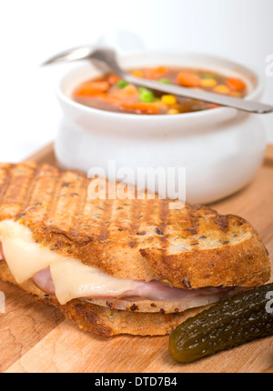 Frisch gebackene Schinken, Schweinefleisch und Schweizer Käse Panini mit Gemüse Suppe und Süßkartoffel Pommes frites serviert. Stockfoto