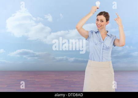 Zusammengesetztes Bild der edle Geschäftsfrau, die Glühbirne über dem Kopf halten Stockfoto