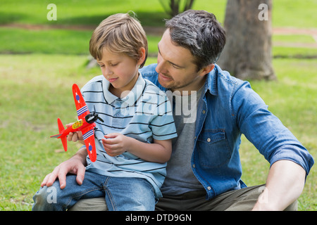 Junge mit Spielzeug Flugzeug auf Vaters Schoß Stockfoto