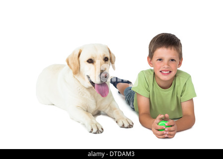 Niedliche kleine Junge mit Ball am Boden liegend mit seinem labrador Stockfoto