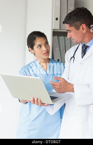 Arzt und Krankenschwester diskutieren über laptop Stockfoto