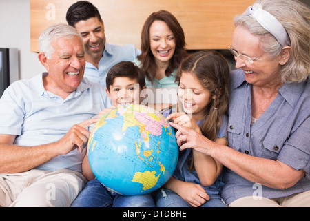 Großfamilie auf Sofa mit Globus im Wohnzimmer sitzen Stockfoto