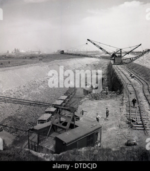 Geschichtsbild aus der 1950er Jahre zeigen Industriekrane auf Schienen Unternehmen große Erde oder Boden Ausgrabung zu skalieren. Stockfoto