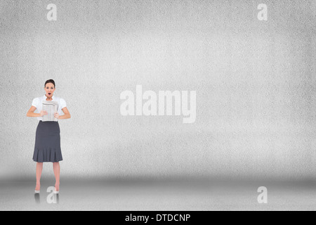 Zusammengesetztes Bild schockiert stilvolle Geschäftsfrau hält Zeitung Stockfoto