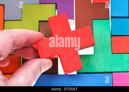 setzen Kreuz geformt Block in bunte Holzpuzzle isoliert auf weißem Hintergrund Stockfoto