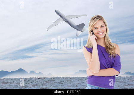 Zusammengesetztes Bild glücklich blonde Frau mit ihrem Handy Stockfoto
