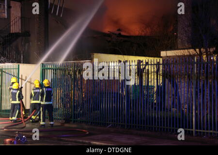 London, UK. 16. Februar 2014. 100 Feuerwehrleute bekämpfen ein Lager Feuer in Canning Town. Ein Mann wurde gerettet und ins Krankenhaus gebracht, wie Crews aus ganz London auf die Szene gesendet wurden. Das Feuer wird angenommen, dass bei etwa 23:00 Samstag begonnen haben und unter Kontrolle gebracht wurde, von ca. 02:00 m Sonntag Morgen. Bildnachweis: HOT SHOTS/Alamy Live-Nachrichten Stockfoto