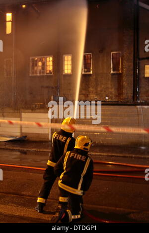 London, UK. 16. Februar 2014. 100 Feuerwehrleute bekämpfen ein Lager Feuer in Canning Town. Ein Mann wurde gerettet und ins Krankenhaus gebracht, wie Crews aus ganz London auf die Szene gesendet wurden. Das Feuer wird angenommen, dass bei etwa 23:00 Samstag begonnen haben und unter Kontrolle gebracht wurde, von ca. 02:00 m Sonntag Morgen. Bildnachweis: HOT SHOTS/Alamy Live-Nachrichten Stockfoto