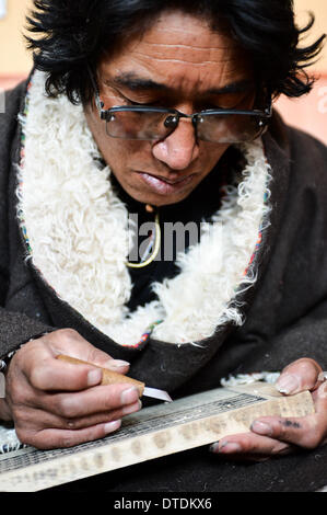 (140216) - DARI, 16. Februar 2014 (Xinhua)--Bolo, Schüler von Aang Jiancuo, Erbe der De'ang Sazhi tibetische Kalligraphie, übt De'ang Sazhi tibetische Kalligraphie in einem Klassenzimmer im De'ang Tempel in Dari County der tibetischen autonomen Präfektur von Golog, Nordwesten Chinas Provinz Qinghai, 15. Februar 2014. Aang Jiancuo, 46, ist der Erbe der De'ang Sazhi tibetische Kalligraphie, die als die nationalen immateriellen Kulturerbe Chinas gelistet ist. Der Erbe gelernt die Kalligraphie von ihm selbst im Alter von 12 und folgte Bazhi, der siebte Erbe der De'ang Sazhi Kalligraphie von 27 Stockfoto