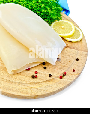 Ganze Tintenfische, Zitrone, Dill, verschiedene Paprika, blaue Serviette auf Holzbrett isoliert auf weißem Hintergrund Stockfoto
