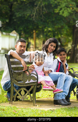 indische Familie sitzt auf der Bank im park Stockfoto