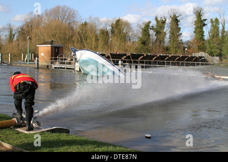 Feuerwehrmann inspiziert ein Schlauch gelegt, um Hochwasser Auspumpen von Runnymede Stockfoto