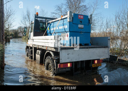 Moor, UK. 16. Februar 2014. Mitarbeiter von der Umweltagentur kommen in das Dorf Moorland im Herzen von der Hochwasserkatastrophe auf der Somerset Levels am 16. Februar 2014. Sie reisen mit Unimog, ein Fahrzeug speziell für Hochwasser und Lieferungen von Öl, Wasser, Nahrung und Sand Taschen zum Dorfbewohner abgeschnitten von den Überschwemmungen bringen. Fast alle Häuser im Moor sind jetzt unter Wasser, mit ein paar bleiben unberührt. Dies ist die schlimmsten Überschwemmungen in der lebendigen Geschichte Credit: Nick Kabel/Alamy Live News Stockfoto