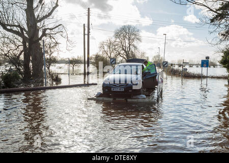 Burrowbridge, UK. 16. Februar 2014. Freiwillige Rettung ein Honda Accord während der schweren Überschwemmungen auf der Somerset Levels am 16. Februar 2014. Das Auto war voll von Sachen und Gefahren auf einem Ponton verwendet, um Fahrzeuge und Tiere zu transportieren und in die überfluteten Gemeinschaft Hilfe verpackt. Die A361 ist eine arterielle Hauptroute über die Somerset Niveaus und hat gerade erlebt den schlimmsten Überschwemmungen in lebendige Geschichte und ist seit sieben Wochen jetzt Unterwasser. Bildnachweis: Nick Kabel/Alamy Live-Nachrichten Stockfoto