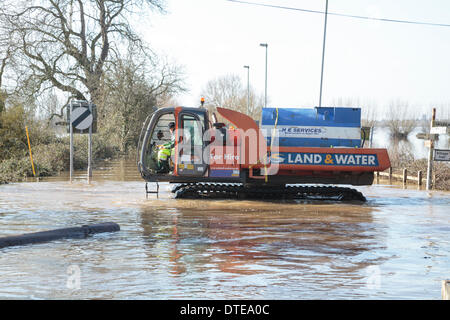 Burrowbridge, UK. 16. Februar 2014. Der Arbeitnehmer während der schweren Überschwemmungen in Burrowbridge auf der Somerset Levels am 16. Februar 2014 von Spezialfahrzeugen verwenden. Fahrzeuge für den Einsatz geeignet sind in tiefem Wasser verwendet wird, um Hindernisse wie Baumstämme und Telegrafenmasten aus dem Wasser zu entfernen, so dass Hilfe an die Anwohner verteilt werden kann. Die A361 ist eine arterielle Hauptroute über die Somerset Niveaus und hat gerade erlebt den schlimmsten Überschwemmungen in lebendige Geschichte und ist seit sieben Wochen jetzt Unterwasser. Bildnachweis: Nick Kabel/Alamy Live-Nachrichten Stockfoto