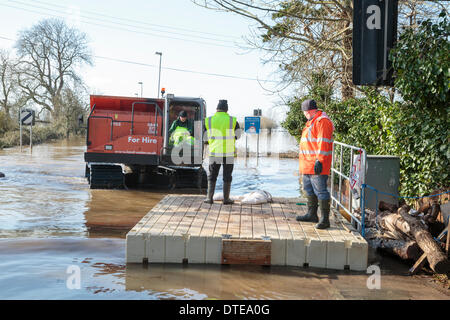 Burrowbridge, UK. 16. Februar 2014. Der Arbeitnehmer während der schweren Überschwemmungen in Burrowbridge auf der Somerset Levels am 16. Februar 2014 von Spezialfahrzeugen verwenden. Fahrzeuge für den Einsatz geeignet sind in tiefem Wasser verwendet wird, um Hindernisse wie Baumstämme und Telegrafenmasten aus dem Wasser zu entfernen, so dass Hilfe an die Anwohner verteilt werden kann. Die A361 ist eine arterielle Hauptroute über die Somerset Niveaus und hat gerade erlebt den schlimmsten Überschwemmungen in lebendige Geschichte und ist seit sieben Wochen jetzt Unterwasser. Bildnachweis: Nick Kabel/Alamy Live-Nachrichten Stockfoto