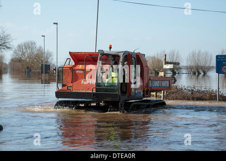 Burrowbridge, UK. 16. Februar 2014. Der Arbeitnehmer während der schweren Überschwemmungen in Burrowbridge auf der Somerset Levels am 16. Februar 2014 von Spezialfahrzeugen verwenden. Fahrzeuge für den Einsatz geeignet sind in tiefem Wasser verwendet wird, um Hindernisse wie Baumstämme und Telegrafenmasten aus dem Wasser zu entfernen, so dass Hilfe an die Anwohner verteilt werden kann. Die A361 ist eine arterielle Hauptroute über die Somerset Niveaus und hat gerade erlebt den schlimmsten Überschwemmungen in lebendige Geschichte und ist seit sieben Wochen jetzt Unterwasser. Bildnachweis: Nick Kabel/Alamy Live-Nachrichten Stockfoto