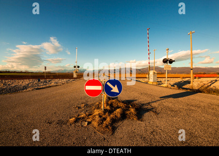 eine isolierte Bahnübergang im Plan von Friaul-Julisch-Venetien. Berge im Hintergrund. Stockfoto