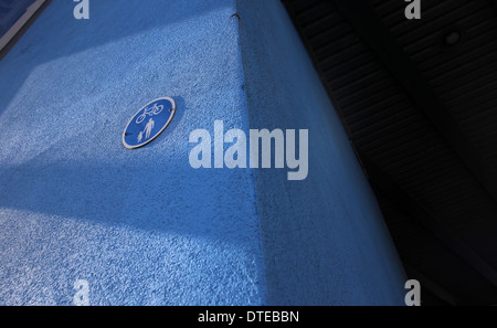 Ein Verkehrszeichen auf Radfahren / Radfahrer und Fußgänger erlaubt. Blaues Schild auf einen blau gestrichenen Wand. Stockfoto