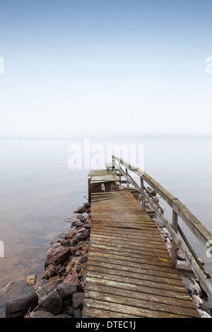 Alte ruiniert hölzerne Pier am Saimaa-See in nebligen Morgen Stockfoto