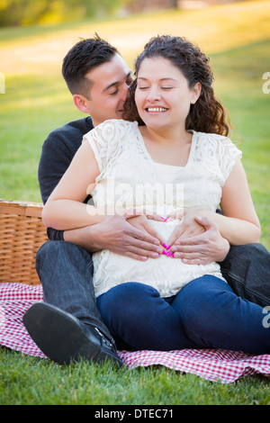 Schwanger hispanische paar machen Herzform mit Hände auf Bauch in der Park-Natur. Stockfoto