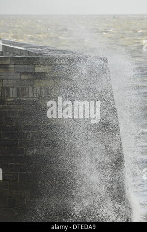 Portsmouth. UK, 15. Februar 2014 1130 bin, die Südküste Englands weiterhin die Auswirkungen der Winterstürme zu spüren. Brechenden Wellen bei Flut mit Southsea Kirmes im Hintergrund Credit: Paul Gordon/Alamy Live News Stockfoto