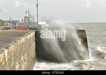 Portsmouth. UK, 15. Februar 2014 1130 bin, die Südküste Englands weiterhin die Auswirkungen der Winterstürme zu spüren. Brechenden Wellen bei Flut mit Southsea Kirmes im Hintergrund Credit: Paul Gordon/Alamy Live News Stockfoto