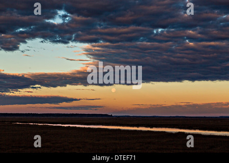 Sonnenaufgang über den Edisto Fluss und Sumpf wie der Mond setzt in Edisto Island, South Carolina. Stockfoto