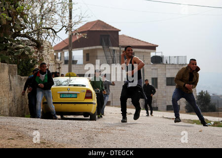 Ramallah, Palästina - 14. Februar 2014:A palästinensischen Steinwürfe Demonstrant Auseinandersetzungen mit israelischen Soldaten (nicht gesehen) während der Zusammenstöße bei einer wöchentlichen Demonstration gegen das Westjordanland jüdische Siedlung von Beit El, in Jalazoun Flüchtlingslager in der Nähe von Ramalla 14. Februar 2014. (Foto von Abdalkarim Museitef/Pacific Press) Stockfoto