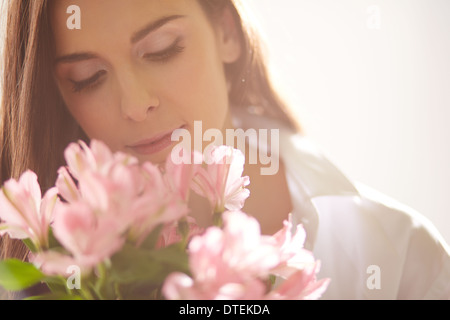Porträt von reizenden Dame rosa Blüten betrachten Stockfoto