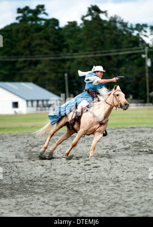 Ein Cowgirl auf einem Pferd Reiten in vollem Galopp mit Pistole gezogen. Annie Oakley Boom Tage Festival in Pinehurst, North Carolina. Stockfoto