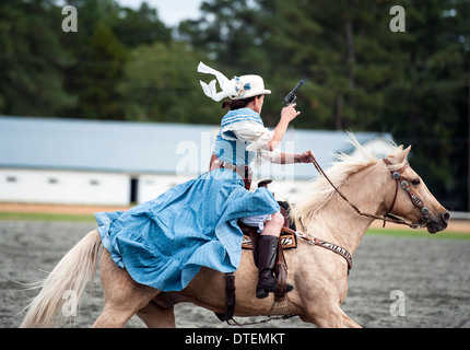 Ein Cowgirl auf einem Pferd Reiten in vollem Galopp mit Pistole gezogen. Annie Oakley Boom Tage Festival in Pinehurst, North Carolina. Stockfoto