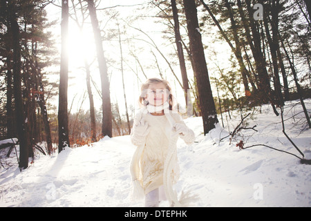 Mädchen (4-5) laufen im Winterwald Stockfoto