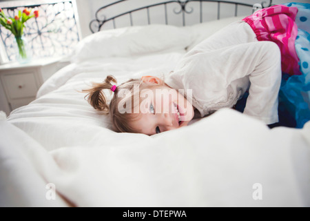 Mädchen (4-5) auf Bett liegend Stockfoto