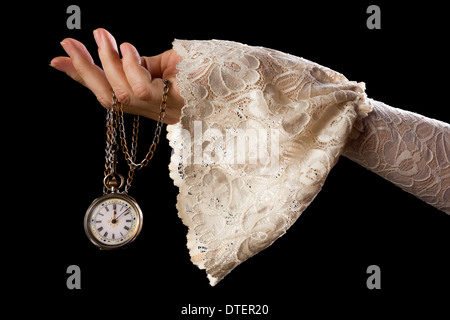 Weibliche Hand in Spitze Ärmel halten einer antiken Taschenuhr an einer Kette Stockfoto
