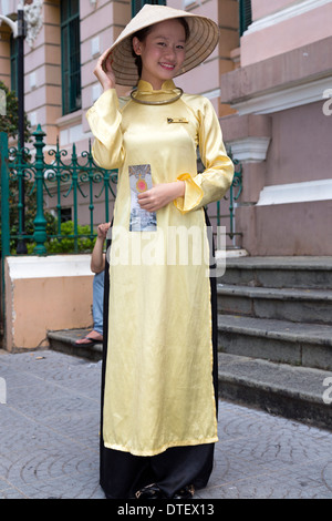 Vietnamesisches Mädchen tragen Ao Dai und Bambushut, Saigon, Vietnam Stockfoto