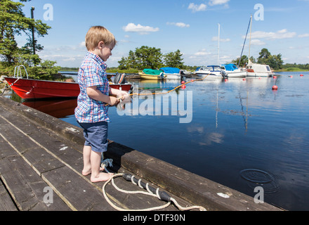 Kalmar, Schweden, Kleinkind Fische mit einem hausgemachten Angeln Stockfoto