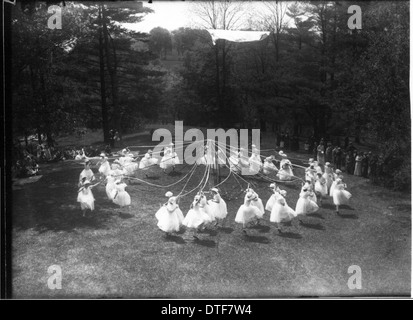 Dieses Foto aus dem Jahr 1916 zeigt den Tree Day am Western College mit Bannern, Mailöchern und Open-Air-Theateraufführungen, die den Schwerpunkt des Colleges auf Frauenbildung und Gemeindeveranstaltungen zu jener Zeit widerspiegeln. Stockfoto