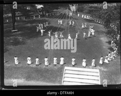 Dieses Foto aus dem Jahr 1926 zeigt eine Feier am Western College in Oxford, Ohio, mit Maypole-Tänzern und Open-Air-Theaterproduktionen. Die Veranstaltung, die Teil der Tradition des Colleges ist, hebt die Rolle der Ausbildung und des Studentenlebens von Frauen hervor, mit Kostümen und Aufführungen, die die kulturelle Lebendigkeit der Zeit widerspiegeln. Stockfoto