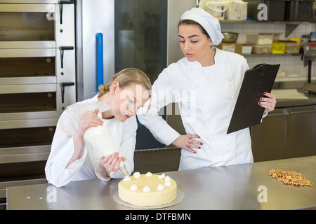 Lehrer in der Lehre Lehrling wie man Kuchen Bäckerei Stockfoto