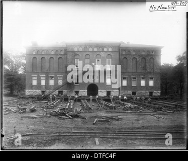 Das Foto zeigt die Verlegung des Herron Gymnasiums 1922 an die Miami University in Oxford, Ohio. Das historische Bild zeigt die logistischen Bemühungen, die Struktur zu verschieben, ein wichtiges Ereignis in der Geschichte der Universität. Das Gymnasium wurde verlegt, um den Campus zu erweitern und seine architektonische Bedeutung zu erhalten. Stockfoto