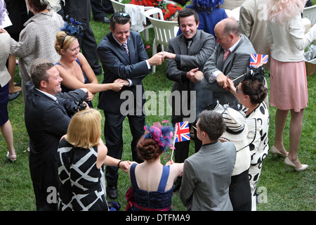 Ascot, Großbritannien, Männer und Frauen bilden einen Kreis und halten die Hände auf die Stockfoto