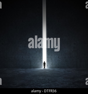 Eine einsame Person, die zu Fuß durch einen schmalen Durchgang Stockfoto