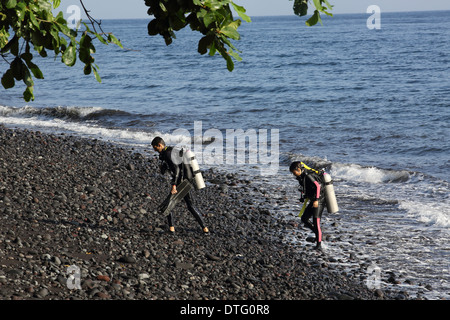 Taucher verlassen das Meer nach dem Tauchen in Tulamben, Ost Bali Stockfoto