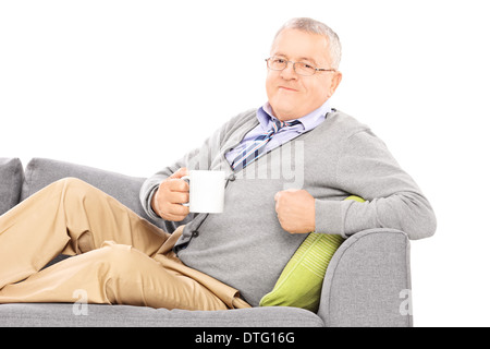 Entspannte reifer Mann Verlegung auf Sofa und Tee trinken Stockfoto
